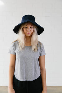 Woman wearing the Serpentine Hat sewing pattern from Elbe Textiles on The Fold Line. A hat pattern made in denim or canvas fabric, featuring a broad brim.
