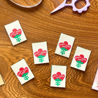 'Sewn with Love' woven labels from Pattern Paper Scissors on The Fold Line. The pack includes 6 woven labels ready to be sewn into your handmade clothes.