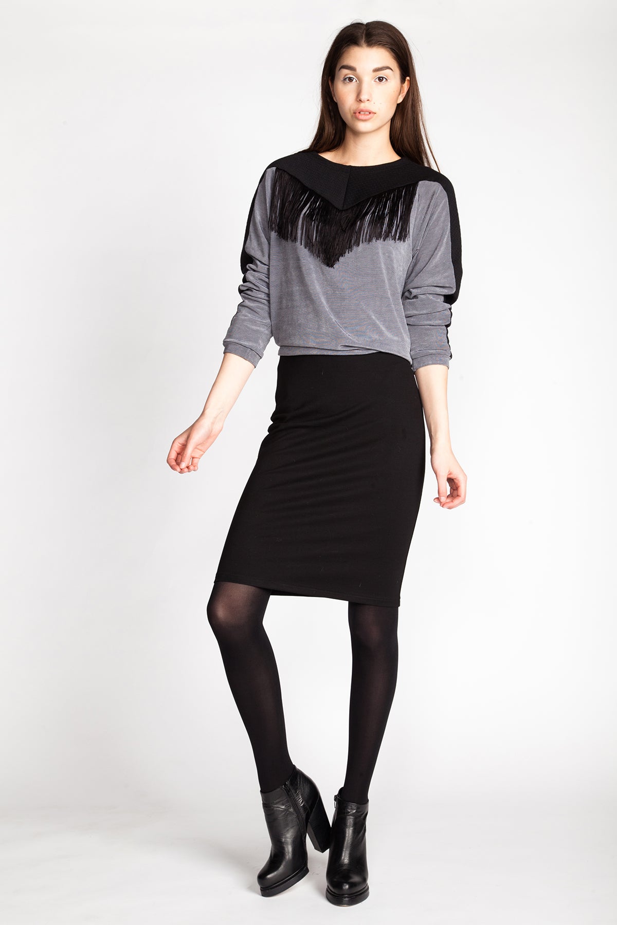 Woman wearing the Shadi Pencil Skirt sewing pattern from Named on The Fold Line. A skirt pattern made in knit fabric, featuring a high waist, elasticated waistband, and knee length.