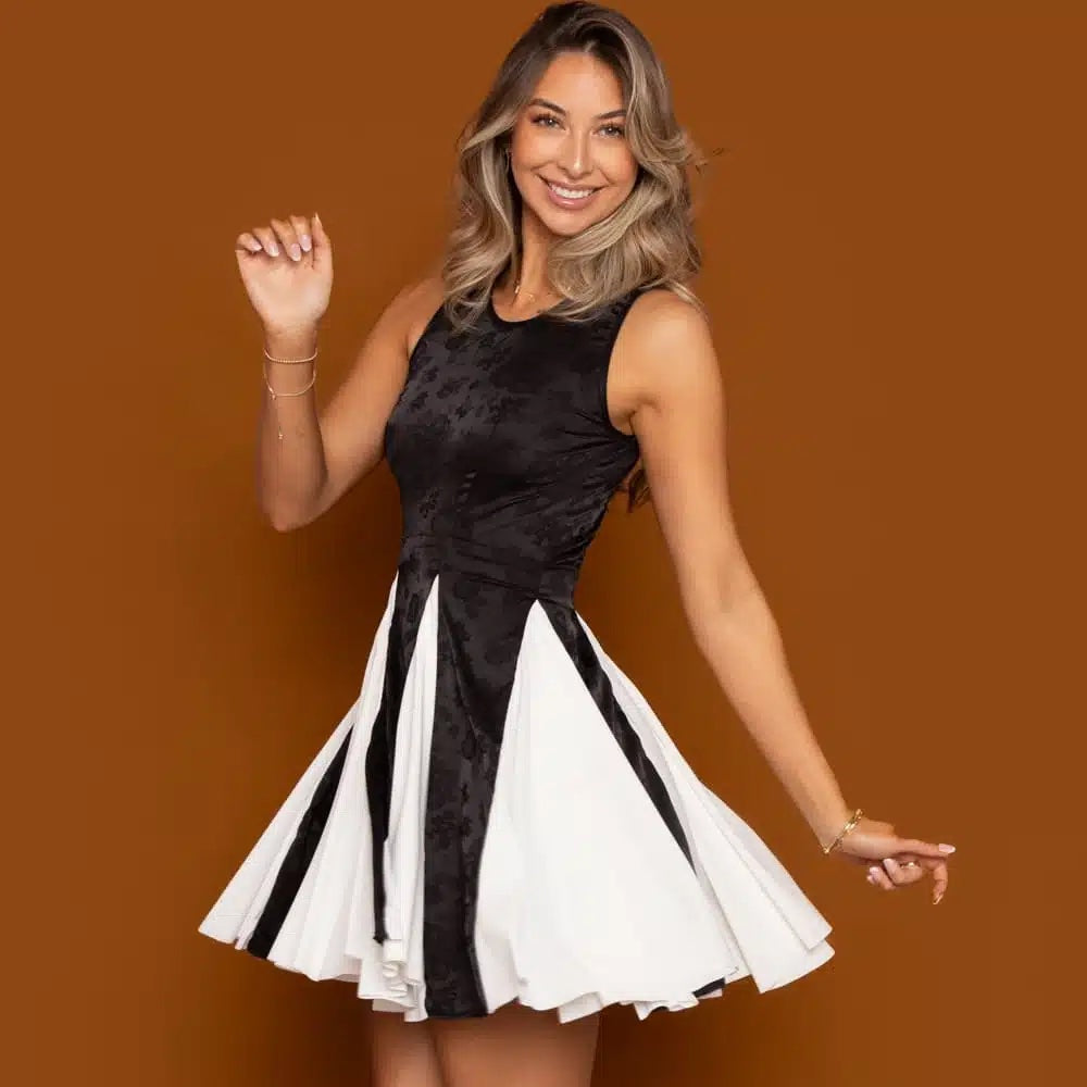 Woman wearing the Sharlett Dress sewing pattern from Madalynne on The Fold Line. A sleeveless dress pattern made in lycra, stretch velvet, stretch all over lace, knit, or jersey fabric, featuring a fitted bodice, flared skirt with six godets, and mini length.