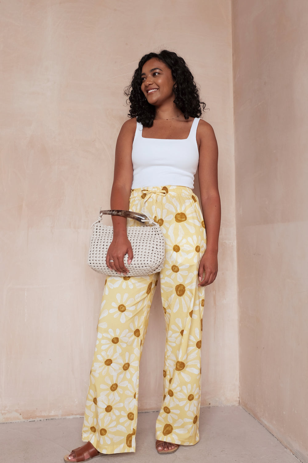 Woman wearing the Sienna Trousers sewing pattern from NH Patterns on The Fold Line. A pants pattern made in lightweight cotton, cotton chambray, linen and linen blends, tencel twill, or rayon/viscose fabric, featuring an elasticated waistband with a drawstring detail, straight wide legs, and side seam pockets.