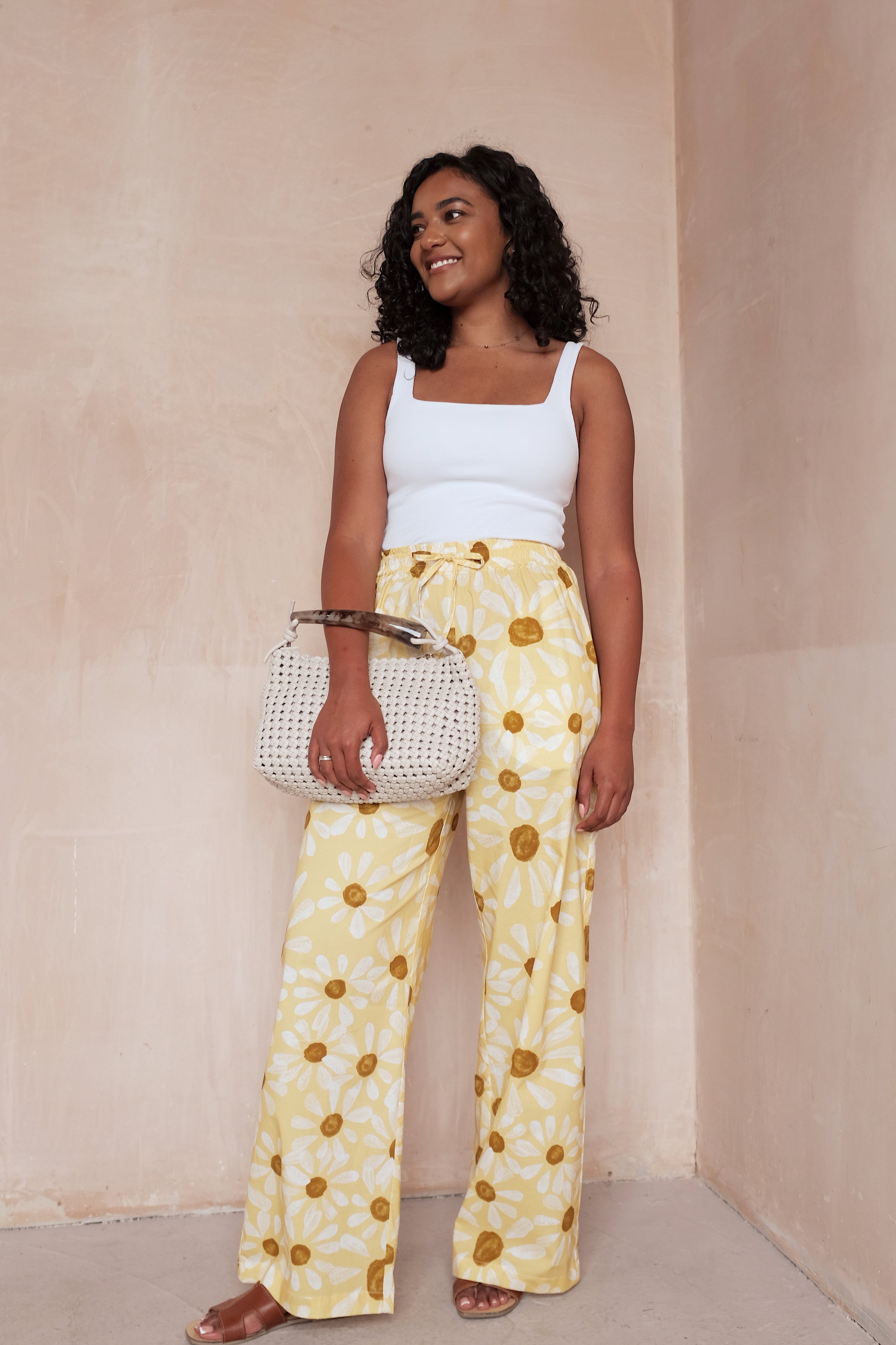 Woman wearing the Sienna Trousers sewing pattern from NH Patterns on The Fold Line. A pants pattern made in lightweight cotton, cotton chambray, linen and linen blends, tencel twill, or rayon/viscose fabric, featuring an elasticated waistband with a drawstring detail, straight wide legs, and side seam pockets.