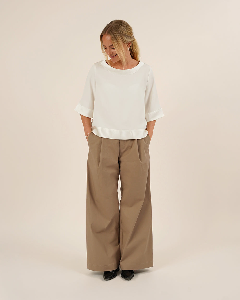 Woman wearing the Silke Blouse sewing pattern from Wardrobe by Me on The Fold Line. A top pattern made in silk, cotton, or viscose fabric, featuring a relaxed silhouette, round neckline, and elbow-length sleeves.