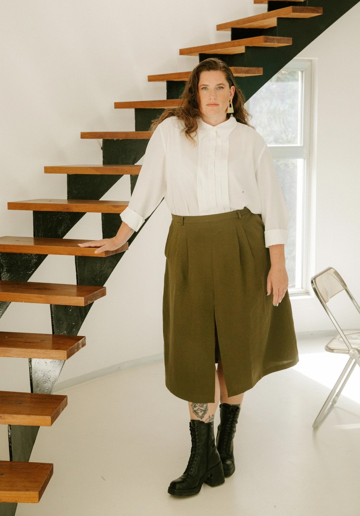 Woman wearing the Silvana Skirt sewing pattern from Maison Fauve on The Fold Line. A skirt pattern made in heavy viscose or tencel twill, light wool, linen, dupion, or soft jacquard fabric, featuring a waistband with belt loops, pockets, front pleats, front slit, back darts, back invisible zip, and midi length.