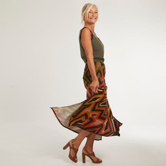 Woman wearing the Simplement Skirt and Top sewing pattern from Coralie Bijasson on The Fold Line. A skirt and top pattern made in viscose crepe, silk satin, or cotton fabric for the skirt and knit fabric for the top, featuring a midi length bias-cut skirt with side slits and a tank top.