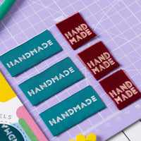 The 'Simply Handmade 4.0' woven labels from Little Rosy Cheeks on The Fold Line. The pack includes 6 labels with a berry or teal background, ready to be sewn into your handmade clothes.
