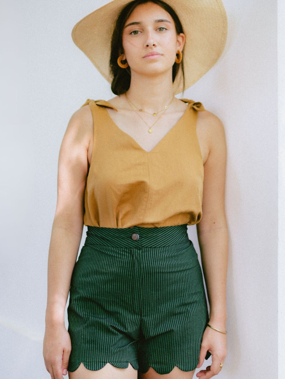 Woman wearing the Sinai Top sewing pattern from Notches on The Fold Line. A sleeveless top pattern made in viscose, tencel, crepe, cotton, or linen fabric, featuring a V-neckline and tie straps.