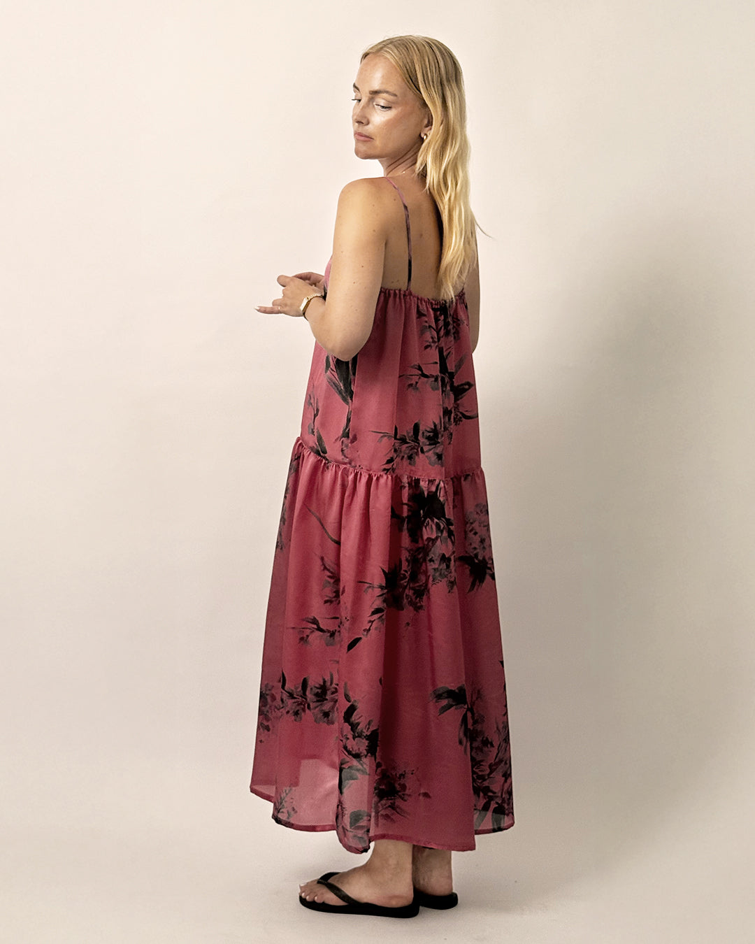 Woman wearing the Skagen Dress sewing pattern from Wardrobe by Me on The Fold Line. A dress pattern made in cotton, linen, silk or viscose fabric, featuring thin straps, a gathered neckline, and long gathered tier.