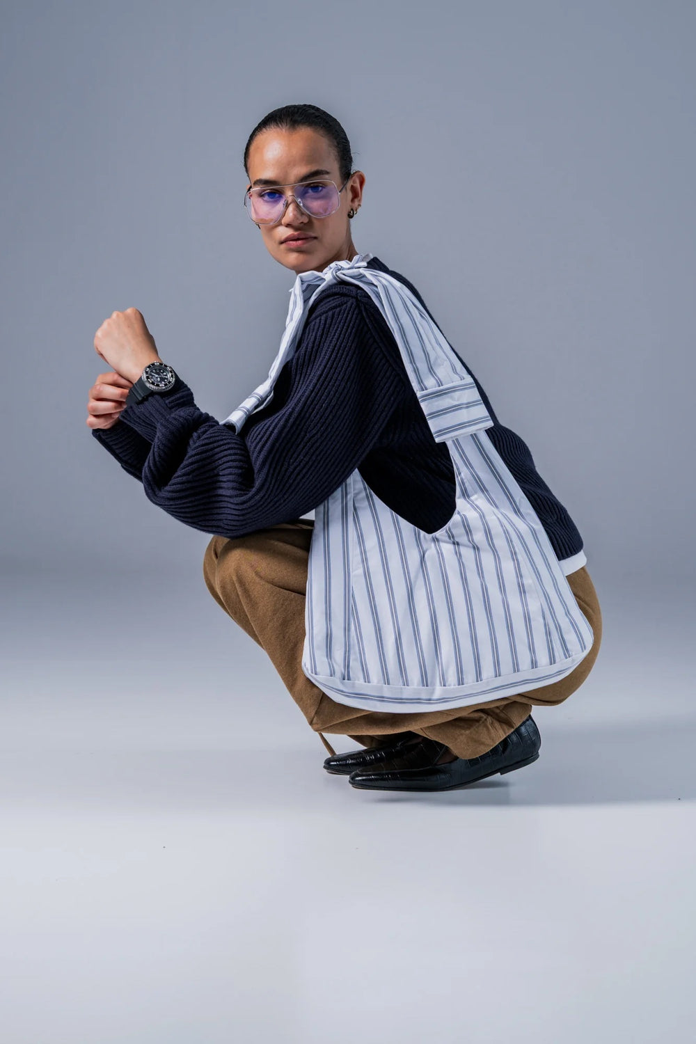 Woman carrying the Sofora Bag sewing pattern from Fibre Mood on The Fold Line. A lined bag pattern made in denim, corduroy, velvet, cotton twill, woven jacquard, or leather fabric, featuring straps that tie at the top.