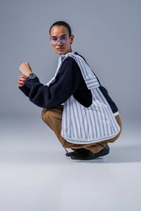 Woman carrying the Sofora Bag sewing pattern from Fibre Mood on The Fold Line. A lined bag pattern made in denim, corduroy, velvet, cotton twill, woven jacquard, or leather fabric, featuring straps that tie at the top.