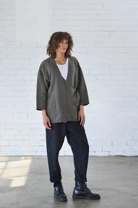 Person wearing the Solberg Jacket sewing pattern from Elbe Textiles on The Fold Line. A jacket pattern made in washed linen, linen/viscose, cotton, tencel, or hemp fabric, featuring a relaxed fit, dropped shoulders, 3/4 length sleeves, and an asymmetrical panel with a D-ring closure.
