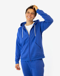 Man wearing the Solstice Hoodie sewing pattern from Helen's Closet on The Fold Line. A hoodie pattern made in knit fabric, featuring a relaxed fit, dropped shoulders, front zip, front pockets, and a drawstring hood.