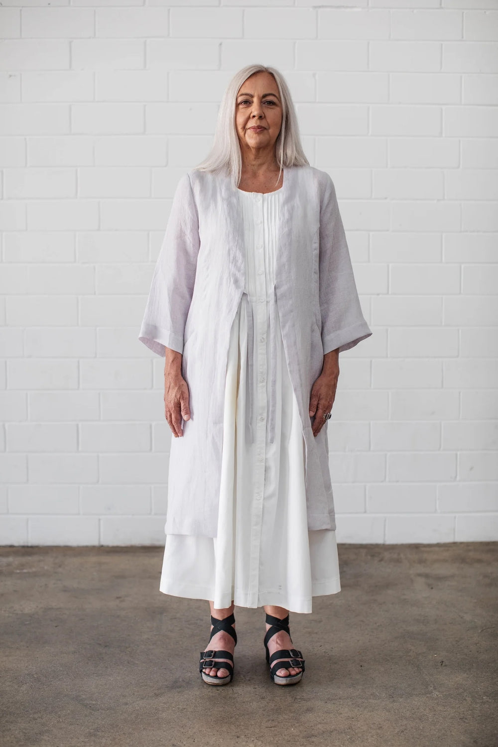 Woman wearing the Somerfield Coat sewing pattern from Elbe Textiles on The Fold Line. A coat pattern made in silk crepe de chine, washed linen, soft cotton, soft hemp blends, or lyocell fabric, featuring a relaxed fit, deep V-front with ties, and 7/8 sleeves.