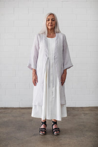 Woman wearing the Somerfield Coat sewing pattern from Elbe Textiles on The Fold Line. A coat pattern made in silk crepe de chine, washed linen, soft cotton, soft hemp blends, or lyocell fabric, featuring a relaxed fit, deep V-front with ties, and 7/8 sleeves.