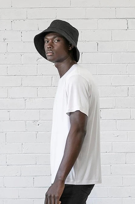 Man wearing the Sorrento Bucket Hat sewing pattern from Elbe Textiles on The Fold Line. A hat pattern made in denim or canvas fabric, featuring a downwards sloping brim.