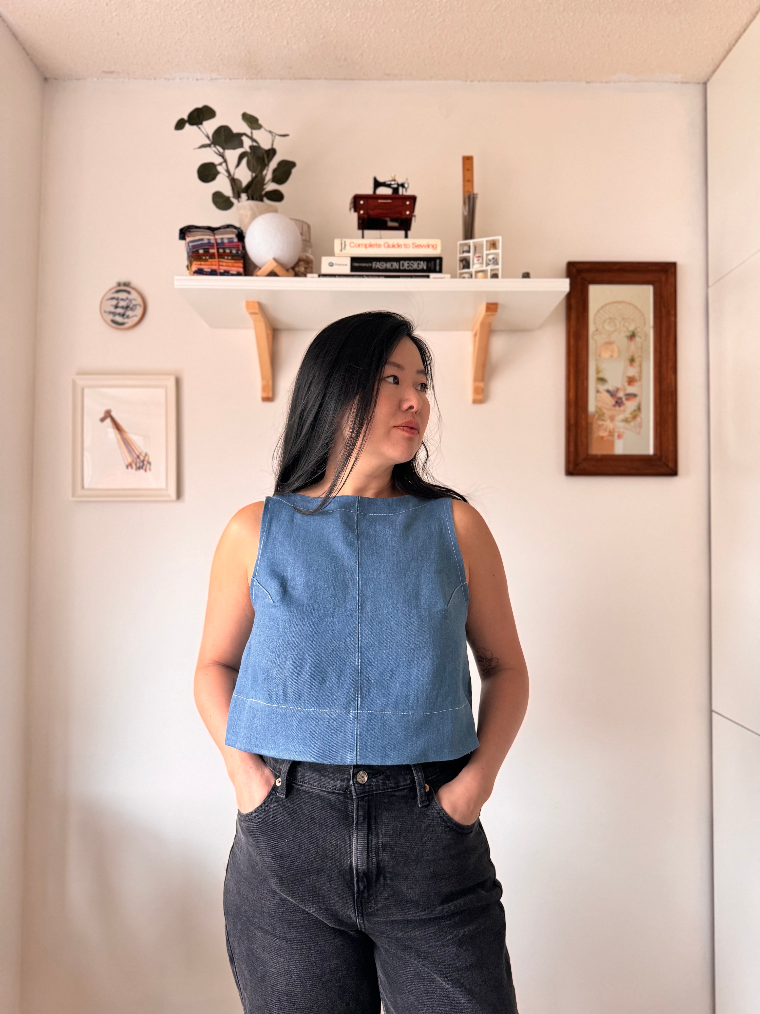 Woman wearing the Sourdough Top sewing pattern from Sew Bake Make on The Fold Line. A sleeveless top pattern made in linen, linen blend, cotton voile, or cotton blend fabric, featuring a boat neckline and crop length.