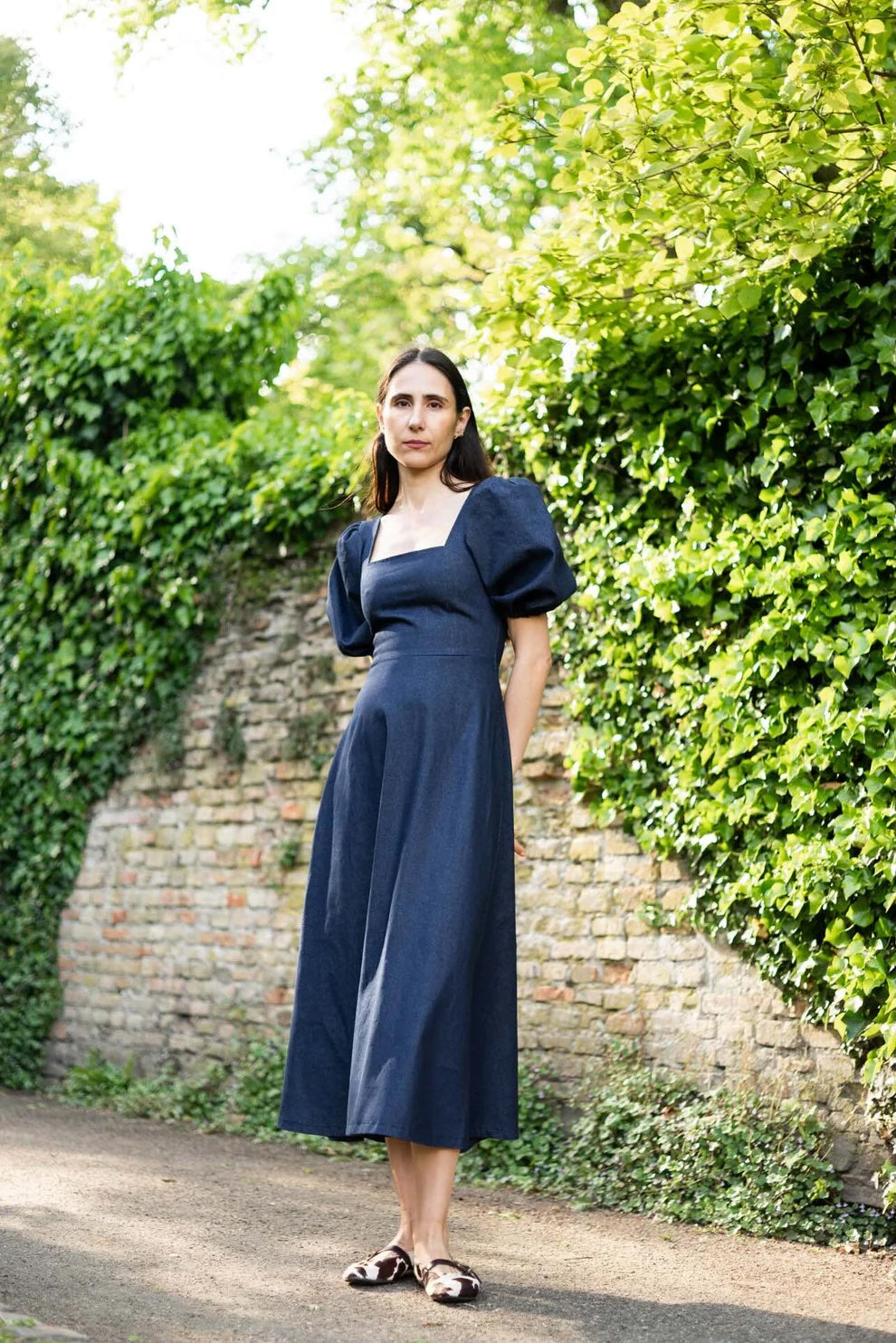 Woman wearing the Square Dress & Puff Sleeve sewing pattern bundle from Puff and Pencil on The Fold Line. A dress and sleeve pattern bundle made in crepe, linen, poplin, woven viscose, taslan, cotton satin, or seersucker fabric, featuring a square neckline, princess seams, short puff sleeves, and midi length.