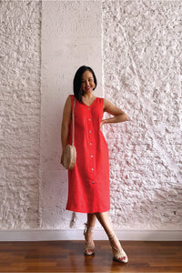 Woman wearing the Stow Dress sewing pattern from In the Folds on The Fold Line. A sleeveless dress pattern made in denim, corduroy, mid to heavy weight cotton, linen, linen blend, or chambray fabric, featuring a slight cocoon shape, V-neck, bust darts, centre front button placket, and in-seam pockets.