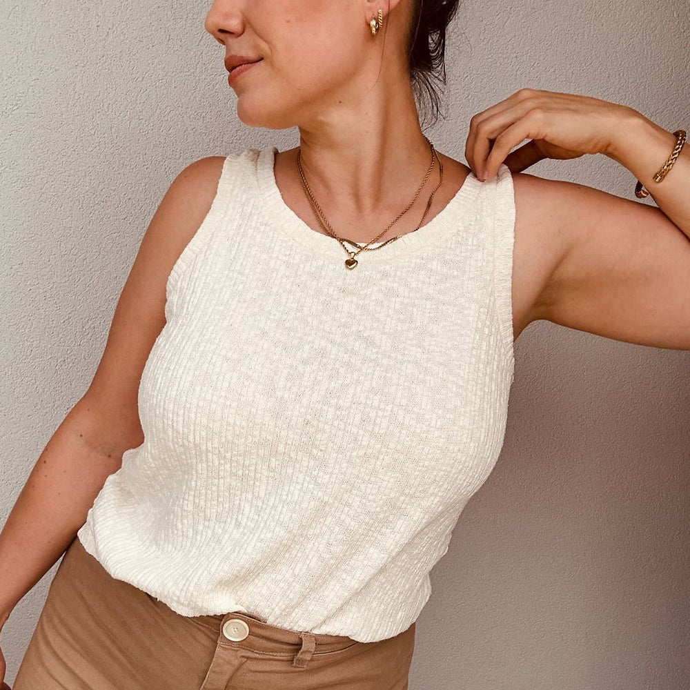 Woman wearing the Suna Tank Top sewing pattern from Sew.lala Patterns on The Fold Line. A sleeveless top pattern made in cotton knit, viscose knit, rib knit, or linen knit fabric, featuring a bound neckline and armholes.