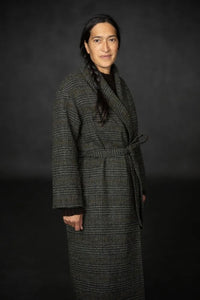 Woman wearing the Sunday Coat Addition sewing pattern from Merchant & Mills on The Fold Line. A lined coat pattern made in wool or tweed fabric, featuring a shawl collar, wrap front, tie belt, and in-seam pockets.