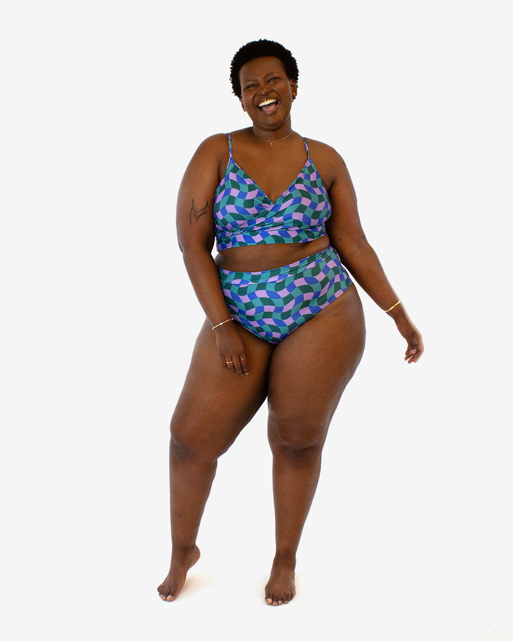 Woman wearing the Sunstar Swimsuit sewing pattern from Helen’s Closet on The Fold Line. A two piece swimsuit pattern made in swimwear stretch knit fabric, featuring a top with a crossover front and thin shoulder straps and high cut bottoms with a cheeky cut in the back.