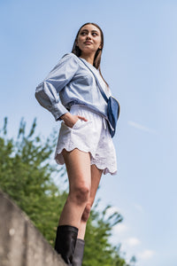 Woman wearing the Tasha Shorts sewing pattern from Fibre Mood on The Fold Line. A shorts pattern made in seersucker, poplin, lyocell, linen, satin, broderie anglaise, crinkle jacquard, double gauze, knit, or crochet fabric, featuring a topstitched elastic waistband, drawstring tie, and in-seam pockets.