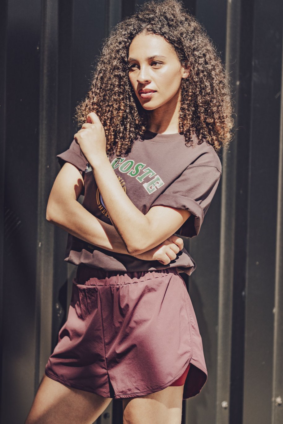 Woman wearing the Tavio Shorts sewing pattern from Fibre Mood on The Fold Line. A sports shorts pattern made in microfibre, nylon taslan, modal, or polyester ripstop fabric, featuring a relaxed fit, elastic waist, and built-in pants.