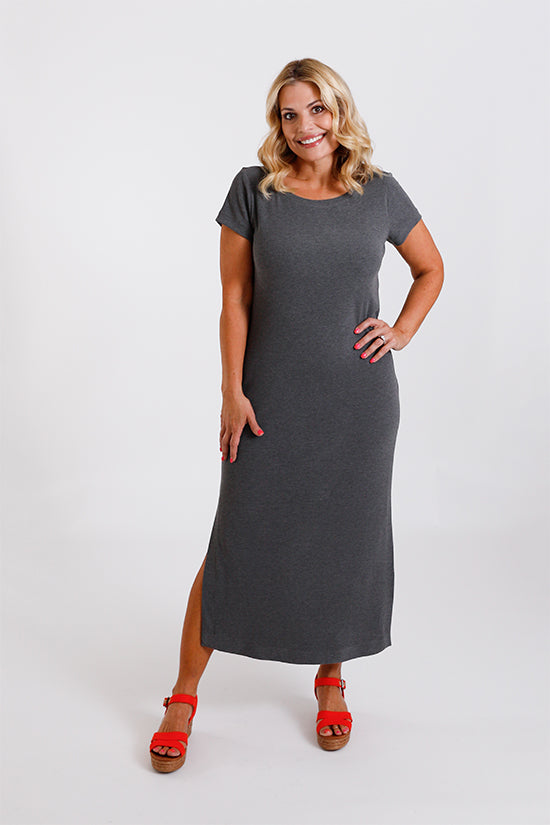 Woman wearing the Tess Dress sewing pattern from Chalk and Notch on The Fold Line. A dress pattern made in jersey, French terry, sweater knit, rib knit, or wool knit fabric, featuring a fitted silhouette, wide ballet style neckline, short sleeves, side slits, and midi length.