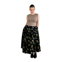 Woman wearing the Tia Skirt sewing pattern from Dhurata Davies Patterns on The Fold Line. A skirt pattern made in linen and linen blends, tencel, viscose, cotton lawn, double gauze, or lightweight poplin fabric, featuring a relaxed fit, elasticated waist, two tiers, in-seam pockets, and midi length.