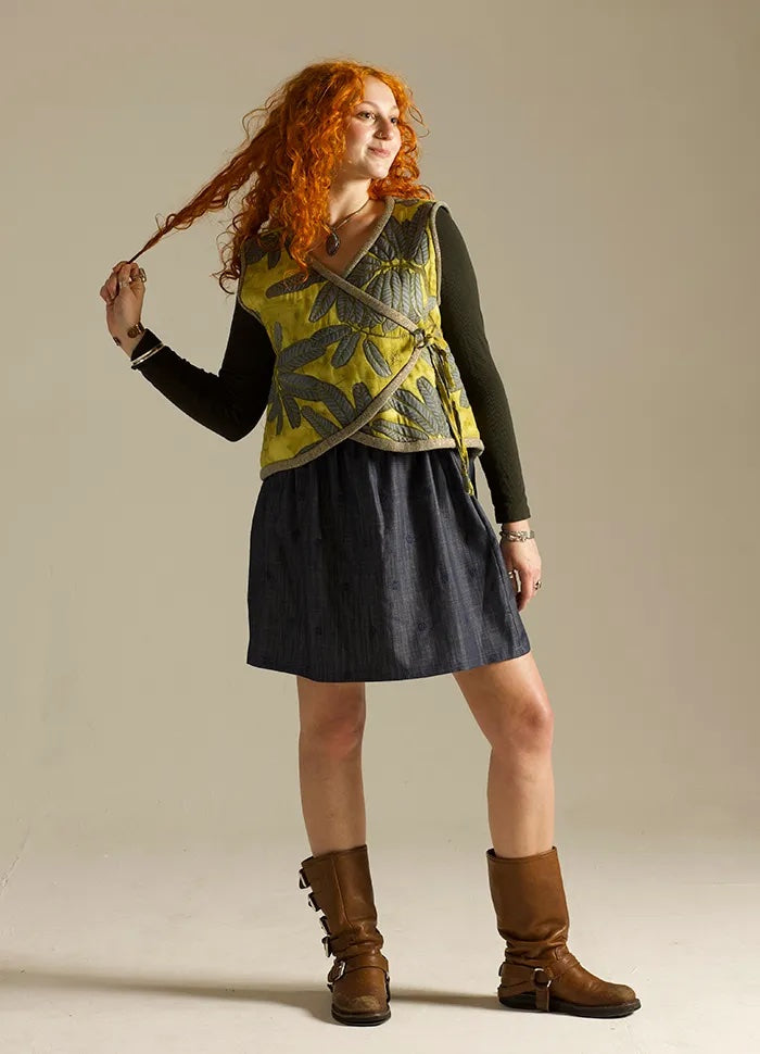 Woman wearing the Tie Bolero sewing pattern from Sew Different on The Fold Line. A quilted vest pattern made in denim, cotton, linen, or viscose fabric, featuring a wrap front with ties and finished with bias binding.