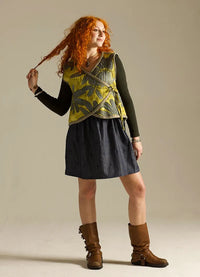 Woman wearing the Tie Bolero sewing pattern from Sew Different on The Fold Line. A quilted vest pattern made in denim, cotton, linen, or viscose fabric, featuring a wrap front with ties and finished with bias binding.