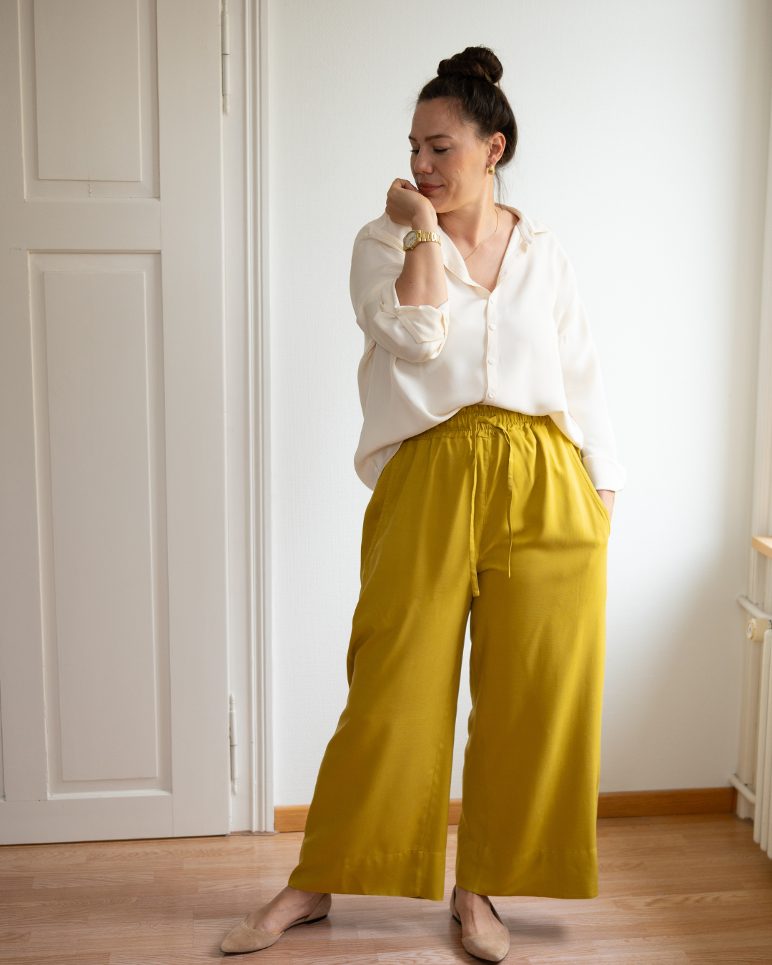 Woman wearing the Tilly Pants sewing pattern from Sew.lala Patterns on The Fold Line. A trousers pattern made in cotton poplin, flannel, washed linen, wool, viscose knit, or lighter sweatshirt fabric, featuring an elastic waist with a drawstring, pockets, and wide leg.
