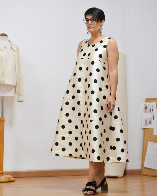 Woman wearing the Tirig Dress sewing pattern from Pauline Alice on The Fold Line. A sleeveless dress pattern made in poplin, linen, lightweight denim, gabardine, corduroy, or wool fabric, featuring an A-line silhouette, topstitching details, and midi length.