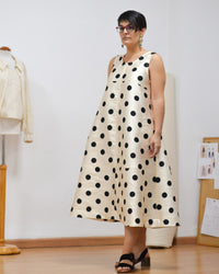 Woman wearing the Tirig Dress sewing pattern from Pauline Alice on The Fold Line. A sleeveless dress pattern made in poplin, linen, lightweight denim, gabardine, corduroy, or wool fabric, featuring an A-line silhouette, topstitching details, and midi length.