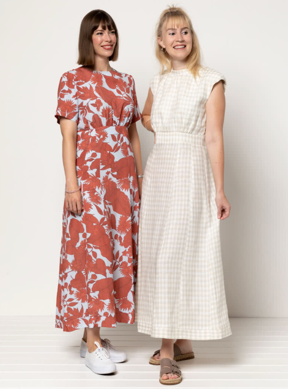 Women wearing the Trinnie Woven Dress sewing pattern from Style Arc on The Fold Line. A dress pattern made in linen, crepe, silk, rayon, or cotton fabric, featuring a round neckline, sleeveless or short sleeves, waistband, 11-panel gored skirt, and ankle length.