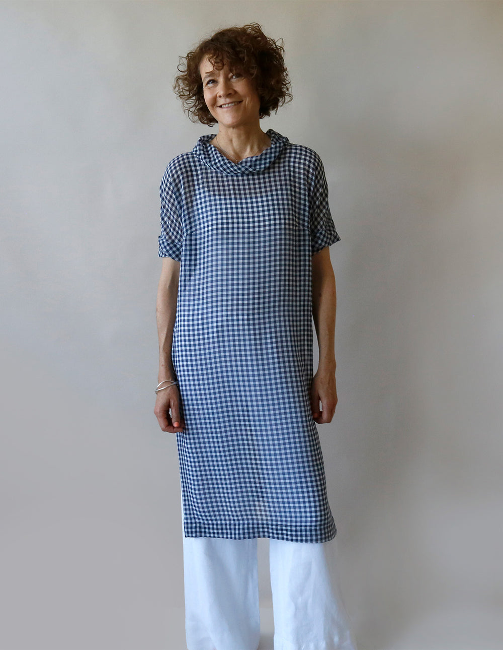 Woman wearing the Tunic Dress and Top sewing pattern from The Maker's Atelier on The Fold Line. A tunic pattern made in cotton, silk, tencel, cupro, modal, or viscose fabric, featuring a twisted neckline, short sleeves, side slits, and knee length.
