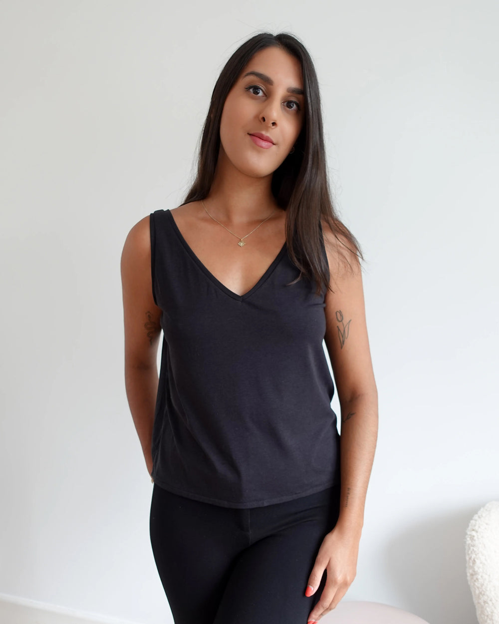 Woman wearing the Tyra Tank sewing pattern from Tammy Handmade on The Fold Line. A sleeveless top pattern made in knit fabric, featuring a relaxed fit and deep V-neckline.