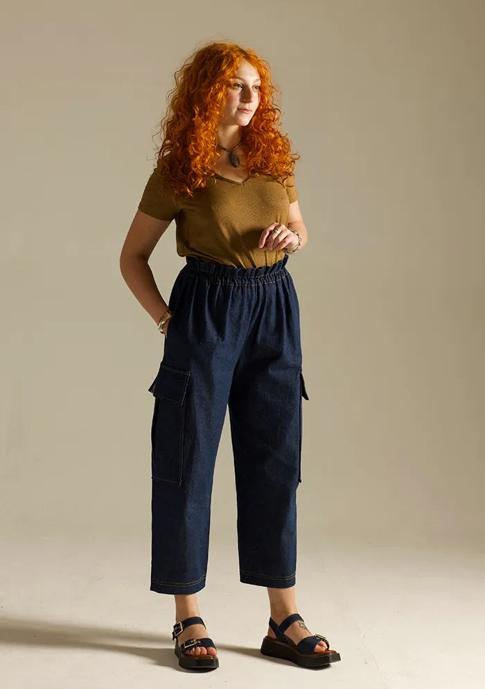 Woman wearing the Tyto Pants sewing pattern from Sew Different on The Fold Line. A trousers pattern made in denim, cotton, corduroy, linen, wool, or twill fabric, featuring an elasticated paperbag waist, in-seam pockets, cargo pockets, and barrel leg shape.