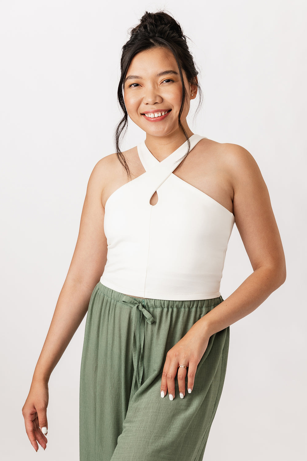 Woman wearing the Ulpu Cross Neck Tank Top sewing pattern from Named on The Fold Line. A top pattern made in firm interlock knit (ponte) fabric, featuring a crossover strap and keyhole detail at the front and a lining with elastic for support.