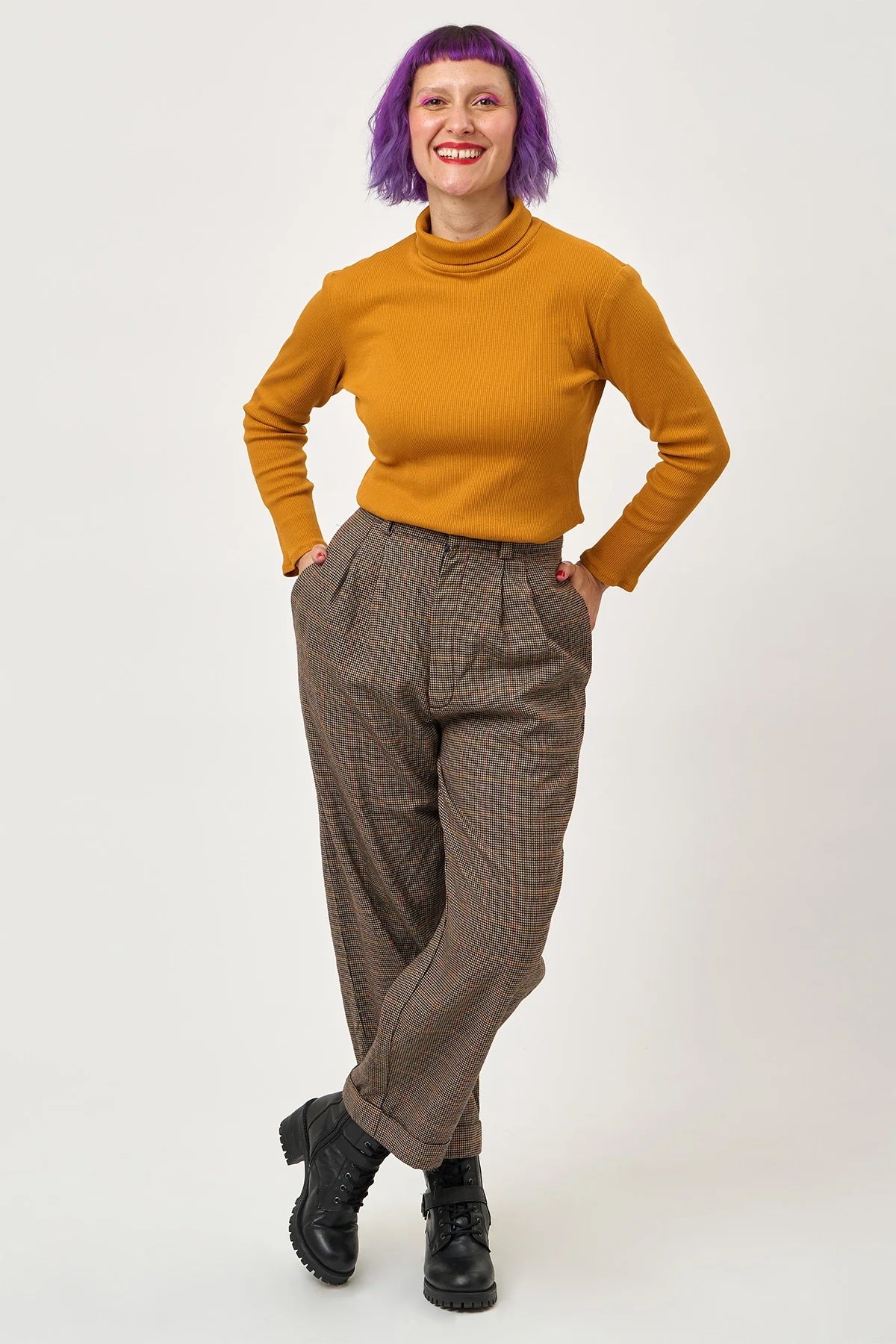 Woman wearing the Ultimate T-shirt Roll Neck Add-on sewing pattern from Sew Over It on The Fold Line. A turtleneck pattern made in viscose or bamboo jersey, French terry, or lightweight cotton jersey fabric, featuring a high neck and long sleeves.