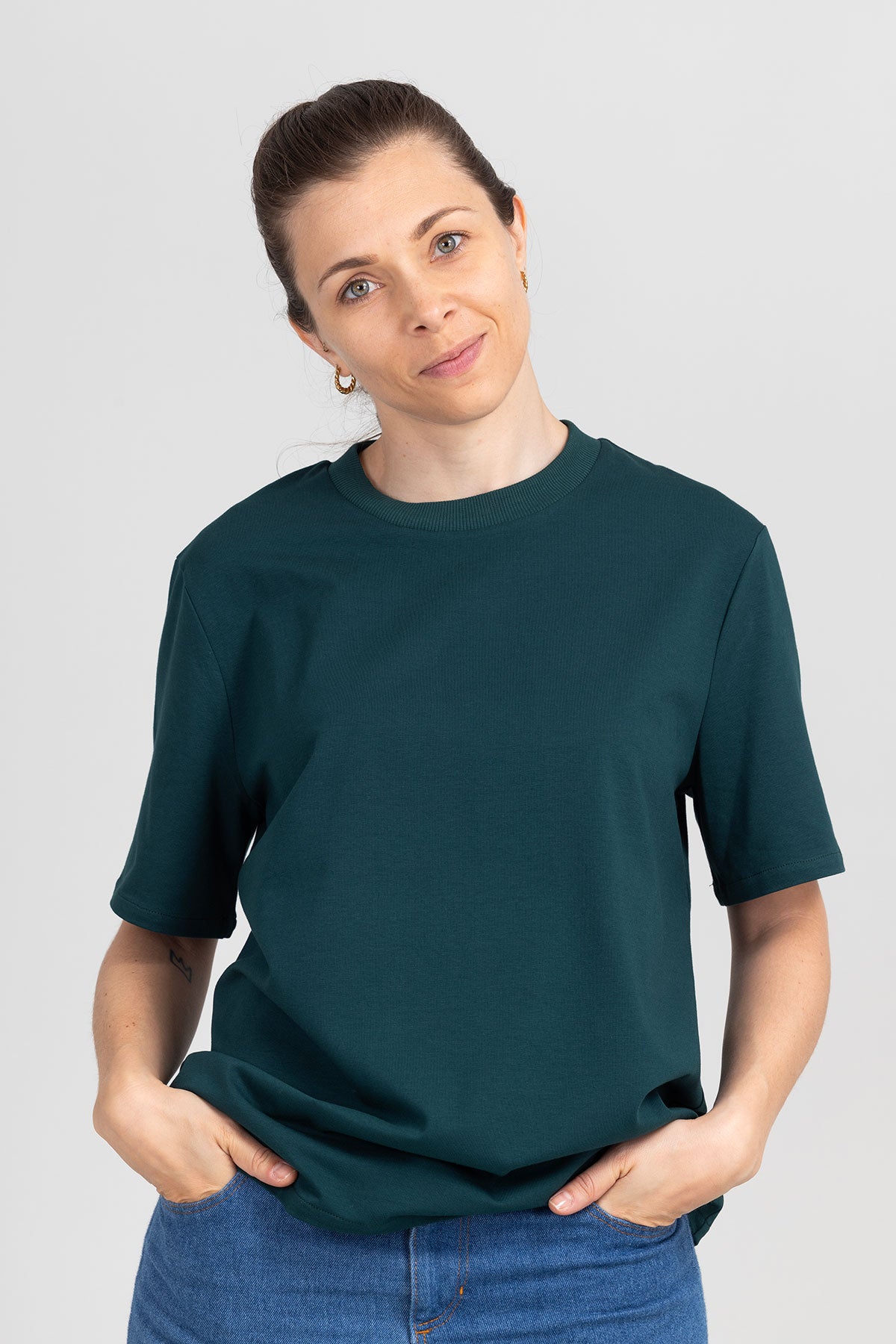 Woman wearing the Unisex Angel T-shirt sewing pattern from I AM Patterns on The Fold Line. A T-shirt pattern made in jersey fabric, featuring a relaxed fit, round neckline, and short to mid-length sleeves.