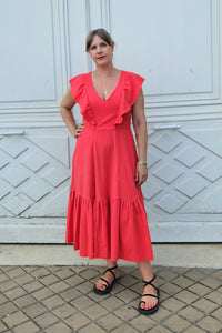 Woman wearing the Valentina Dress sewing pattern from Emporia Patterns on The Fold Line. A sleeveless dress pattern made in cotton poplin or lawn, cotton viscose blend, linen/ramie or blends, cotton sateen, seersucker, lightweight jacquard, double gauze, chambray, or viscose satin fabric, featuring a V-neck, frills that cover the shoulders, princess seams, bound armholes, and a panelled skirt with pockets and a ruffle.