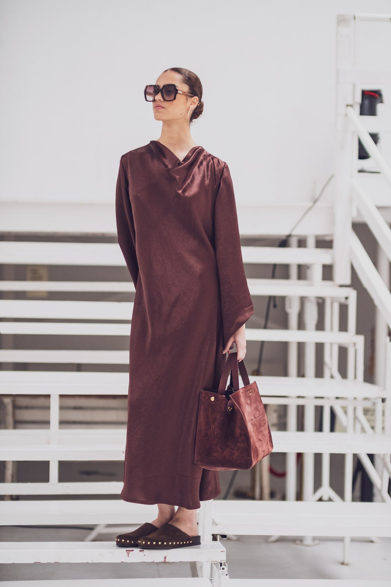 Woman wearing the Vendela Dress sewing pattern from Fibre Mood on The Fold Line. A dress pattern made in satin, acetate, charmeuse, or silk fabric, featuring a cowl neckline, bias cut front, long sleeves, and maxi length.