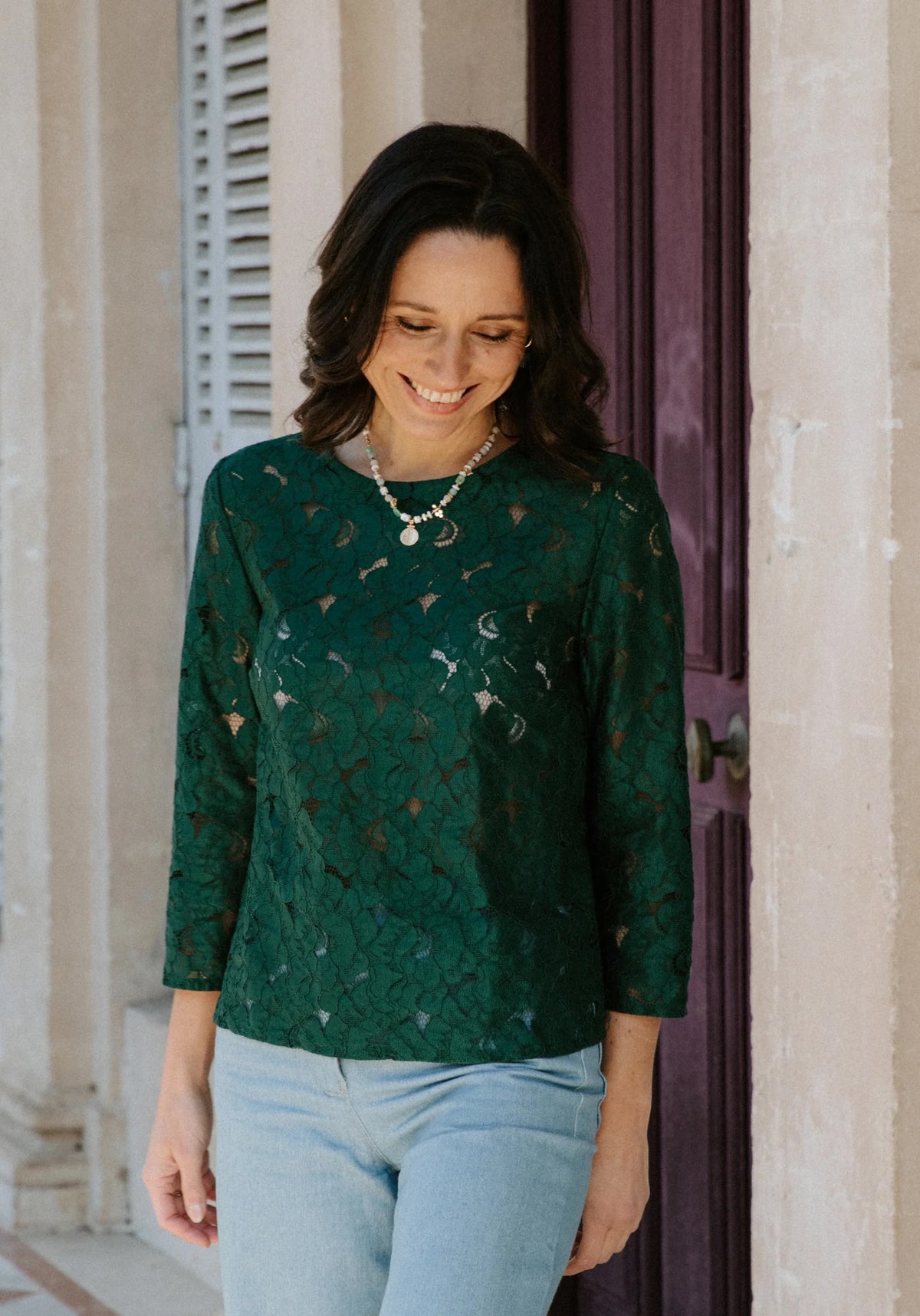 Woman wearing the Violette Blouse sewing pattern from Maison Fauve on The Fold Line. A top pattern made in viscose rayon, lace, silk, cotton, or jersey fabric, featuring a round neckline, three-quarter length sleeves, and a button placket and box pleat in back.