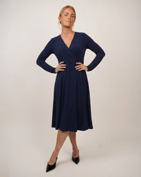 Woman wearing the Wanda Dress sewing pattern from Wardrobe by Me on The Fold Line. A wrap dress pattern made in jersey fabric, featuring a V-neckline, long sleeves, six-gore skirt, and knee length.