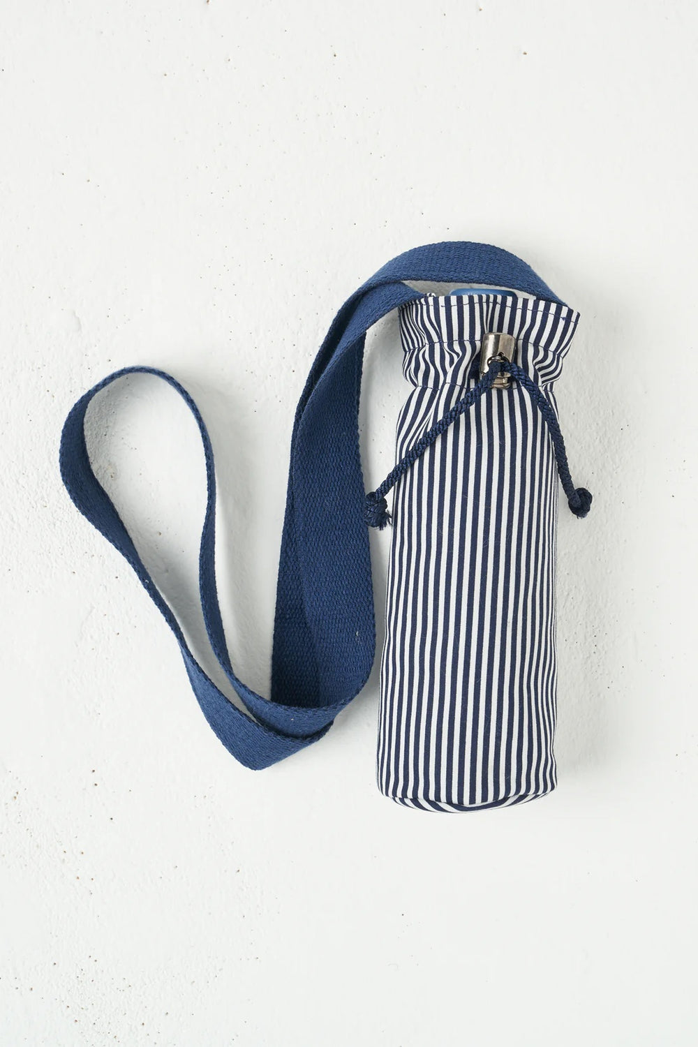 The Water Bottle Holder sewing pattern from Sew Over It on The Fold Line. A water bottle holder pattern made in cotton or canvas fabric, featuring a drawstring closure and webbing strap.