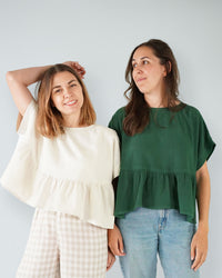 Women wearing the Wave Float Top sewing pattern from Matchy Matchy Sewing Club on The Fold Line. A top pattern made in cotton or linen fabric, featuring a wide oversized fit, grown-on short sleeves, and a gathered peplum.