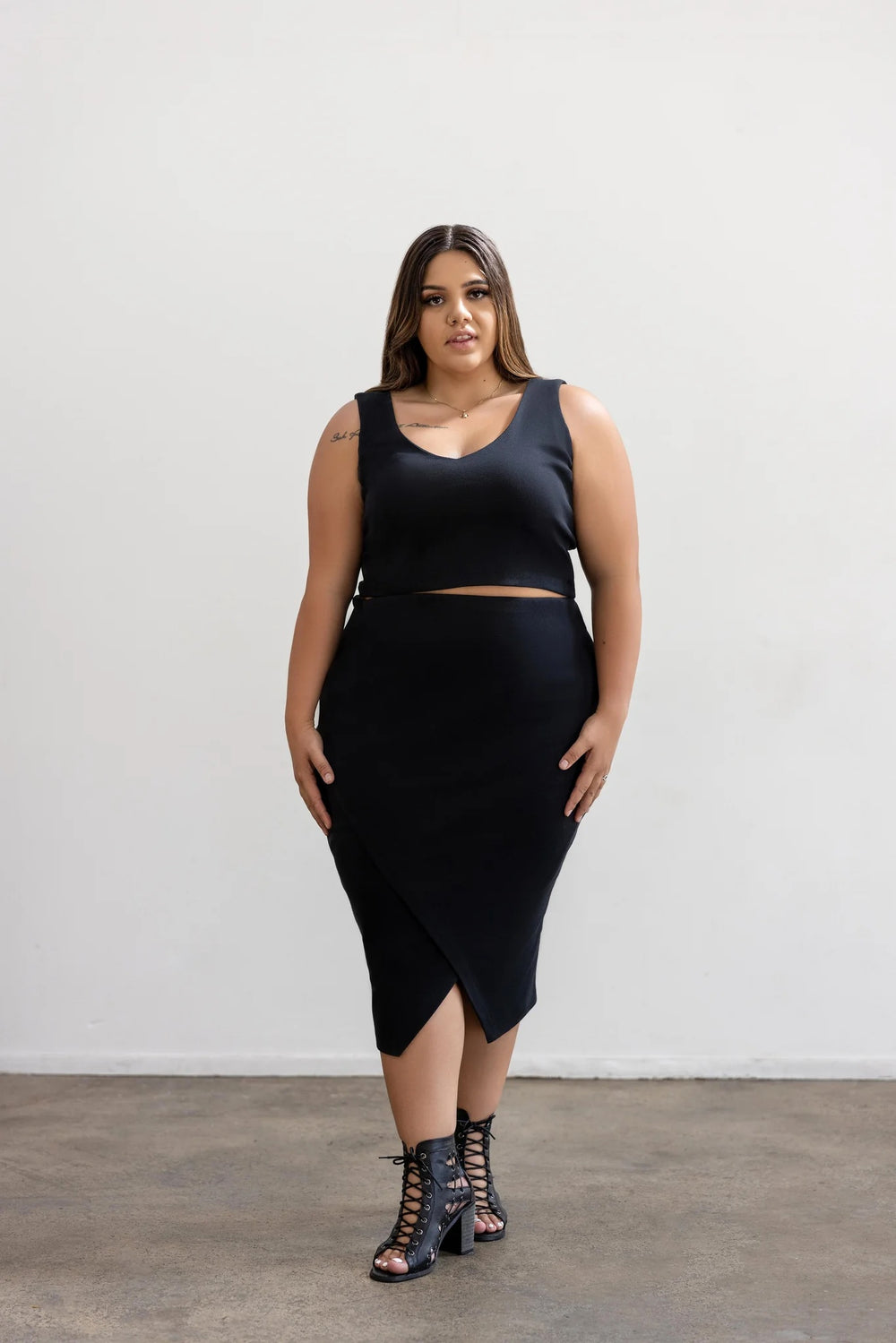 Woman wearing the Weiland Tank sewing pattern from Elbe Textiles on The Fold Line. A sleeveless top pattern made in knit fabric, featuring a low neckline, cropped length, and built-in shelf bra.