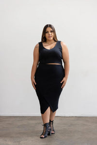 Woman wearing the Weiland Tank sewing pattern from Elbe Textiles on The Fold Line. A sleeveless top pattern made in knit fabric, featuring a low neckline, cropped length, and built-in shelf bra.