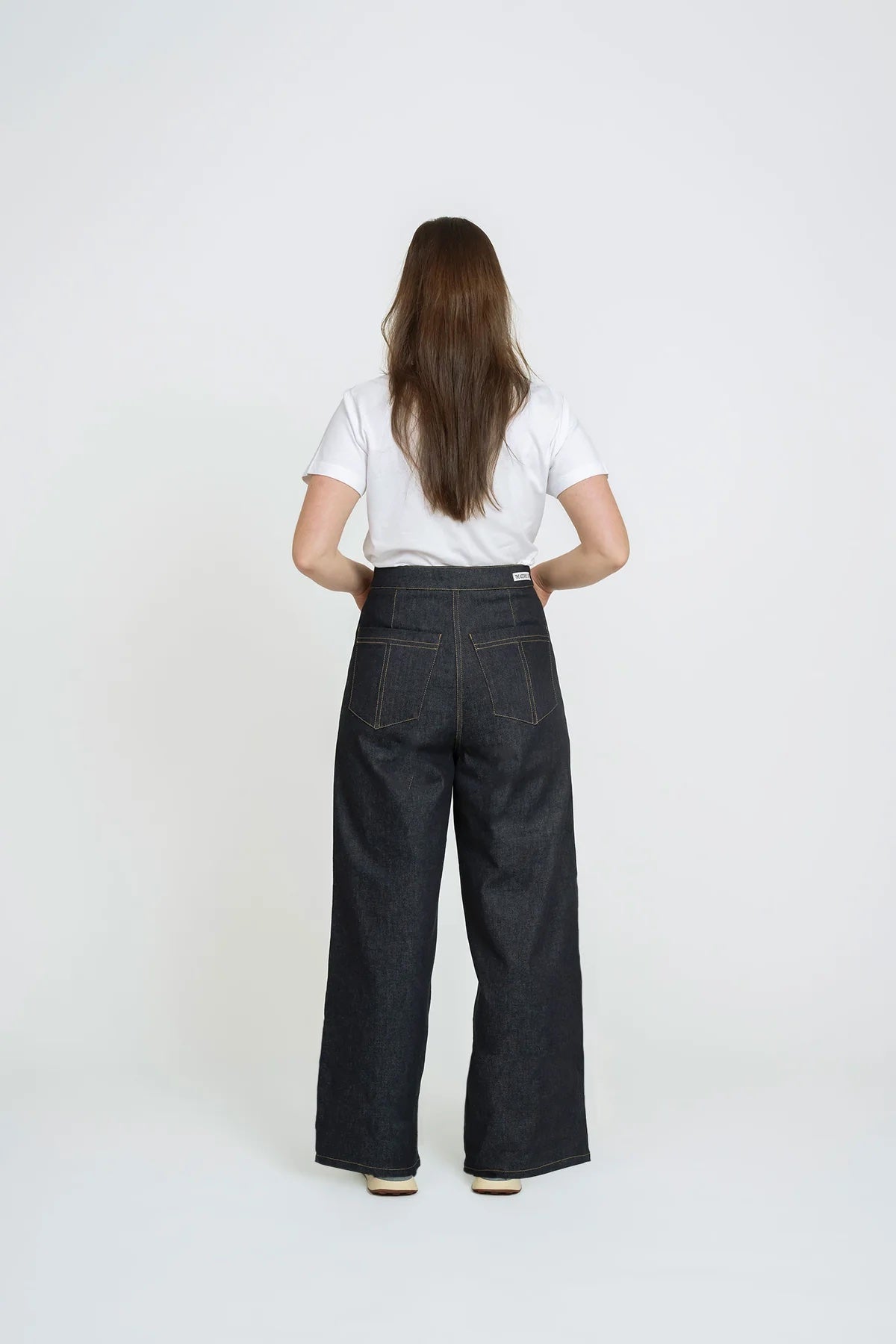 Woman wearing the Wide-Leg Jeans sewing pattern from The Assembly Line on The Fold Line. A jeans pattern made in medium to heavy weight fabric, featuring a high rise waist, zip fly, dropped crotch, front and back pockets, and wide legs.